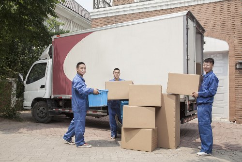 Moving team carrying boxes with safety equipment at a Raynerslane property